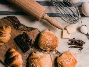 An elegant cutting board featuring a variety of croissants and pastries, showcasing their golden-brown textures 