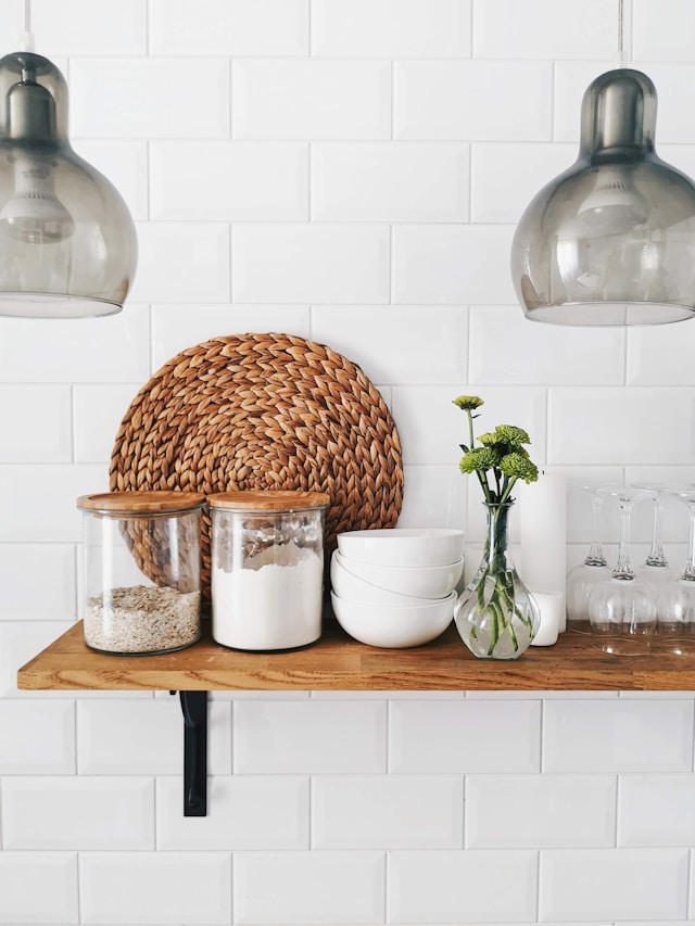 A shelf featuring white tiles adorned with a woven basket, creating a clean and organized aesthetic.